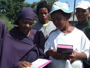 A widowed lady reads the scripture from her new Bible as we share the word and prayer together