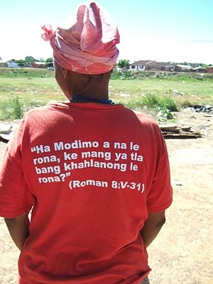 A lady wearing a T shirt speaking out for people with HIV/AIDS.